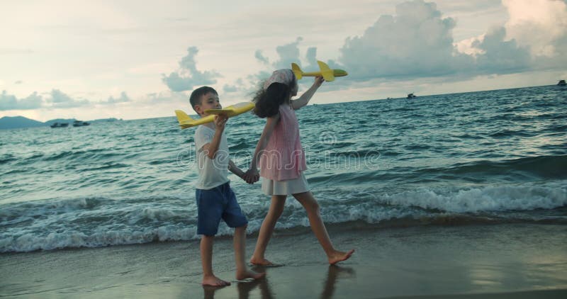 Frère et soeur enfants courent le long de la plage en vacances en famille. Concept enfant vacances plage. Enfants jouant clips vidéos