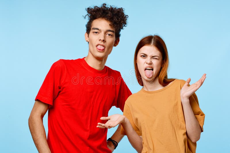 Fröhlich jung paar in mehrfarbigen shirts kommunikation studio blau hintergrund