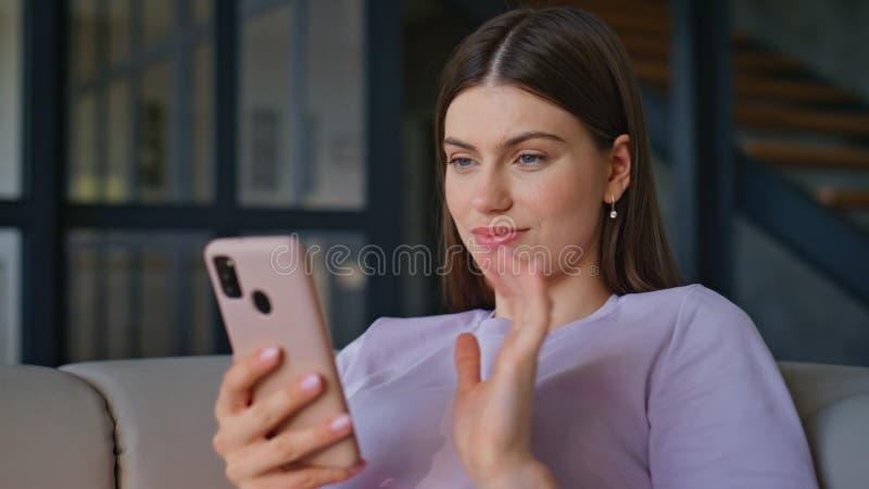 Fröhliche Brunette mit Handy Sitzsofa entspannt Home Einstellung geschlossen stockbild