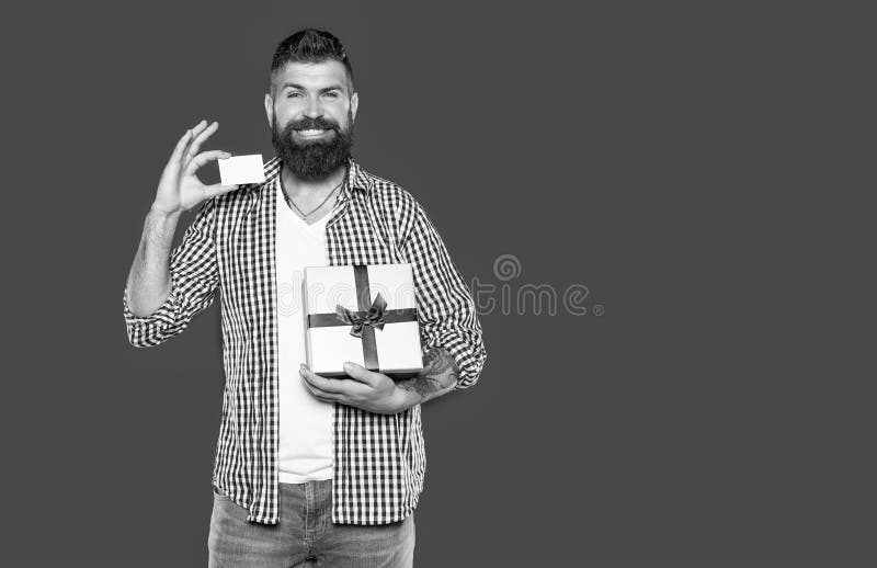 Fröhlicher reifer Bartmann mit Geschenkkarton und Karte lizenzfreie stockfotos
