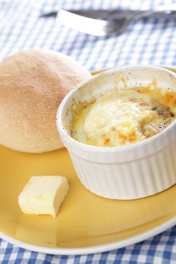 Breakfast with Swiss styled baked eggs in ramekin with the bun. Breakfast with Swiss styled baked eggs in ramekin with the bun