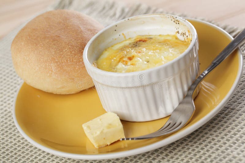 Breakfast with Swiss styled baked eggs, butter, and bun. Breakfast with Swiss styled baked eggs, butter, and bun