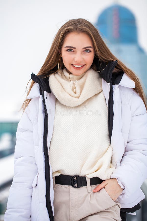 Fshion Girl in a White Down Jacket and Beige Pants Posing Outdoors in ...