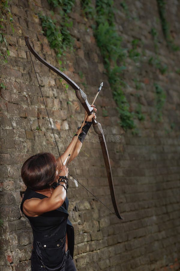 Fucilazione femminile del guerriero dall'arco al cielo fotografia stock Fucilazione femminile del guerriero dall'arco al cielo fotografia stock