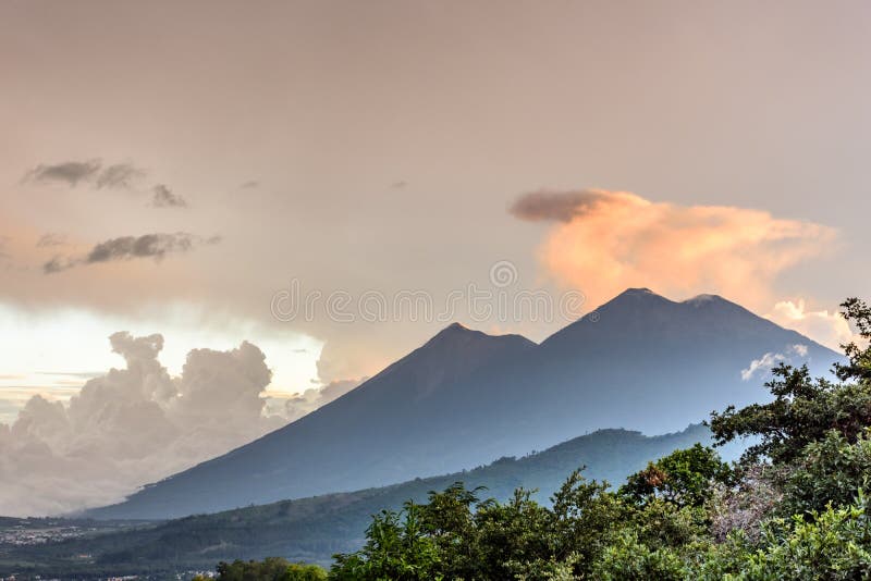 Fuego & Acatenango volcanoes at sunset outside Spanish colonial town & UNESCO World Heritage Site of Antigua in Panchoy Valley, Guatemala, Central America. Fuego & Acatenango volcanoes at sunset outside Spanish colonial town & UNESCO World Heritage Site of Antigua in Panchoy Valley, Guatemala, Central America