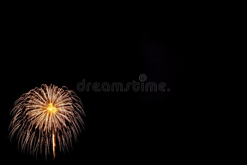 Fuegos artificiales en fondo negro. Los fuegos artificiales de oro en la parte inferior dejaron la esquina en fondo negro