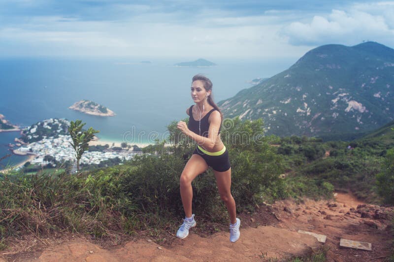 A fuga bronzeada ajuste da mulher dos jovens que corre acima as etapas cinzelou no montanhês com montanhas, mar, ilhas e o céu ne fotos de stock A fuga bronzeada ajuste da mulher dos jovens que corre acima as etapas cinzelou no montanhês com montanhas, mar, ilhas e o céu ne fotos de stock