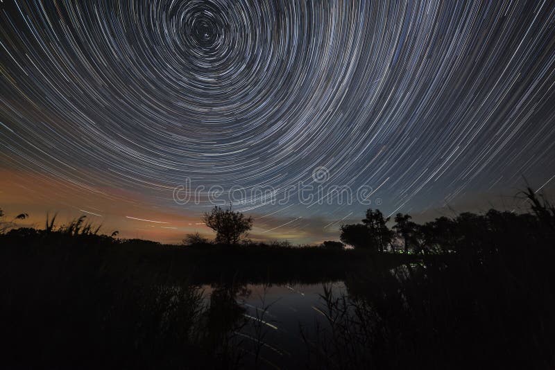 A fuga de protagoniza no céu noturno com as nuvens refletidas no rio Movimento no espaço fotografado na exposição longa imagens de stock royalty free A fuga de protagoniza no céu noturno com as nuvens refletidas no rio Movimento no espaço fotografado na exposição longa imagens de stock royalty free