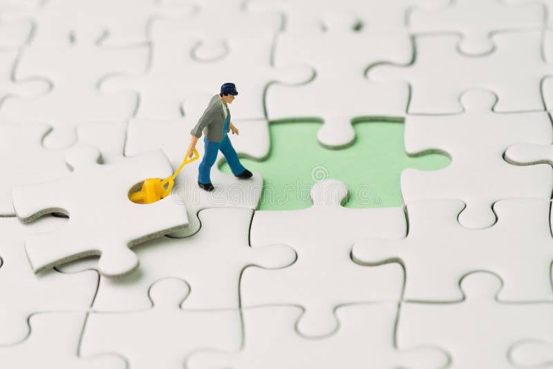 Fulfill the missing piece for business success strategy metaphor, miniature worker figurine using the forklift to complete the last white jigsaw puzzle piece on pastel green background.