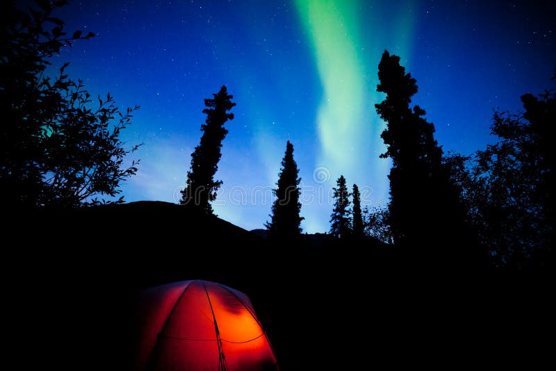 Fulgor alaranjado da barraca do taiga sob o alargamento da aurora boreal fotos de stock Fulgor alaranjado da barraca do taiga sob o alargamento da aurora boreal fotos de stock
