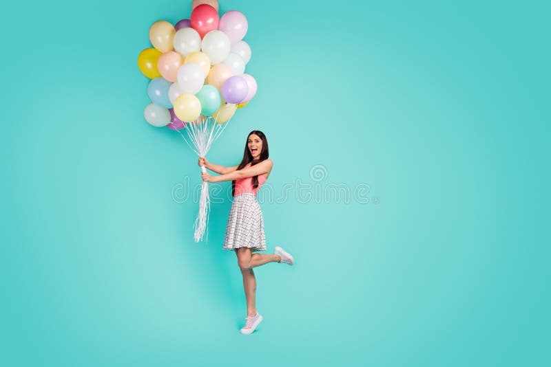 Full body photo of cheerful crazy funny girl hold many air baloons enjoy festive anniversary celebration wear pastel