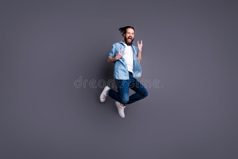 Full body photo of crazy funky cheerful rock roll lover guy jump show horned sign enjoy free time concert party scream stock photography Full body photo of crazy funky cheerful rock roll lover guy jump show horned sign enjoy free time concert party scream stock photography