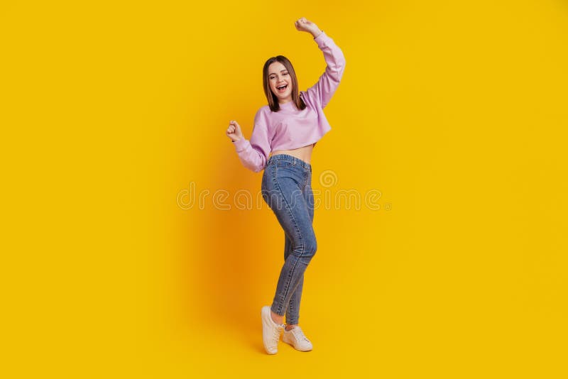 Full body photo of young cheerful girl rejoice victory fists ahnds lucky isolated over yellow color background royalty free stock photo