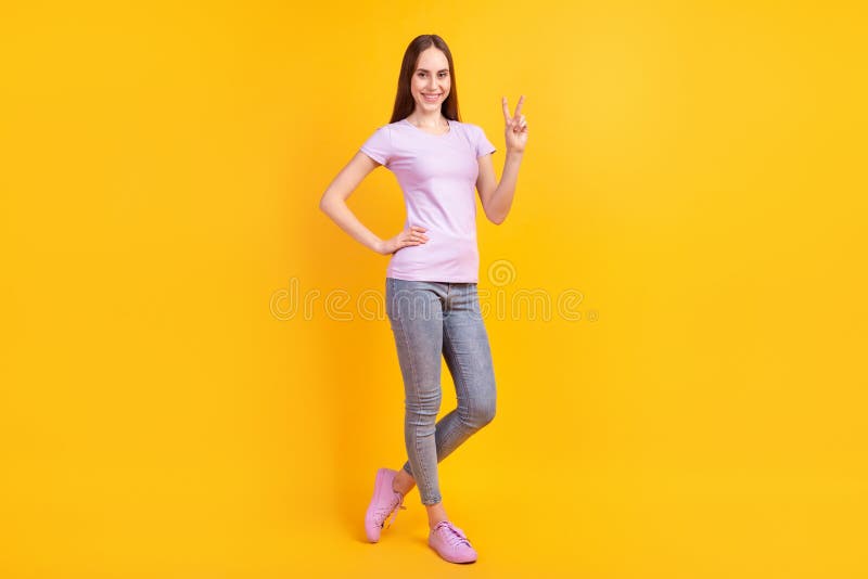 Full body photo of young cheerful girl show fingers peace cool v-symbol isolated over yellow color background royalty free stock photography