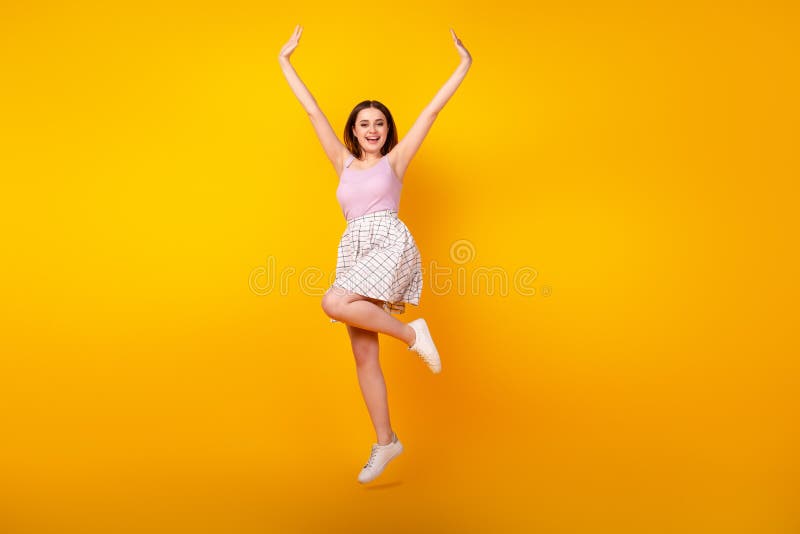 Full body photo of youth lovely lady have fun jump up wear casual clothes isolated over yellow color background stock photos