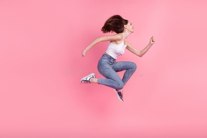 Full body profile side photo of young cheerful girl jump go walk runner empty space isolated over pink color background stock photography