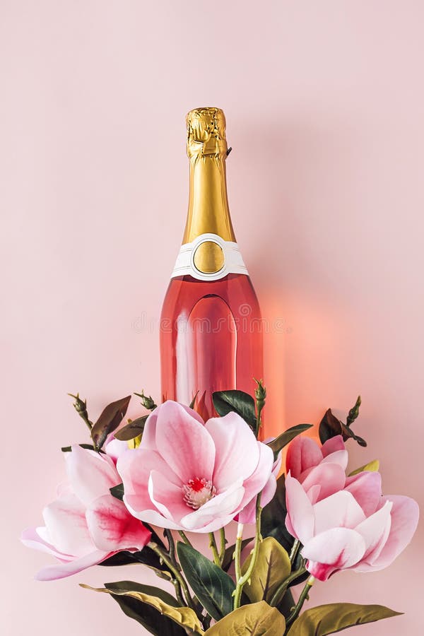 Full bottle of pink champagne with fresh flowers