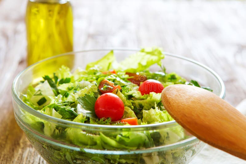 Full bowl of fresh green salad on a wooden table against on a ru stock images Full bowl of fresh green salad on a wooden table against on a ru stock images