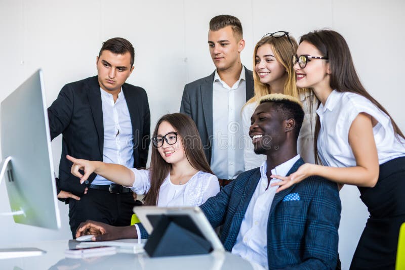 Full concentration at work. Group of young business people working and communicating while sitting at the office desk together stock photos Full concentration at work. Group of young business people working and communicating while sitting at the office desk together stock photos
