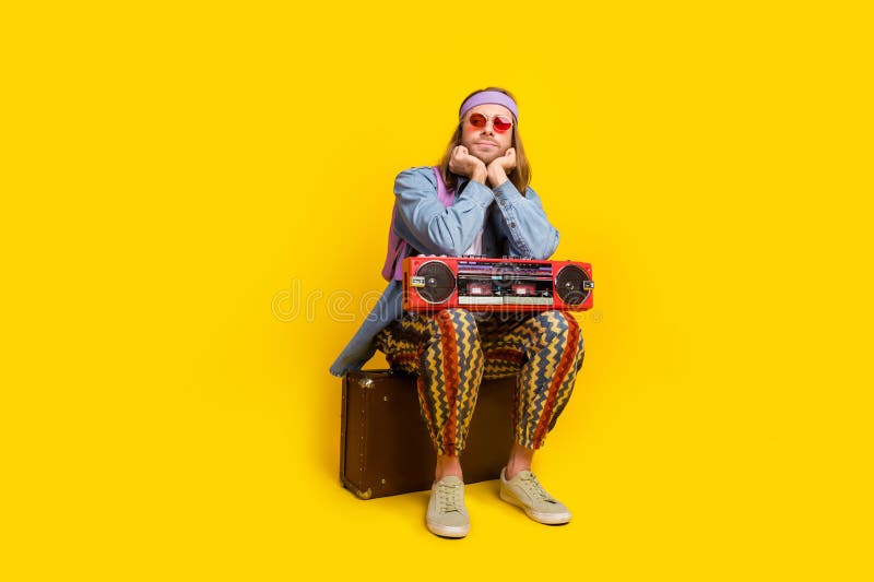 Full size photo of cool handsome guy valise boombox look empty space wear denim shirt isolated on yellow color background. Full size photo of cool handsome guy valise boombox look empty space wear denim shirt isolated on yellow color background.