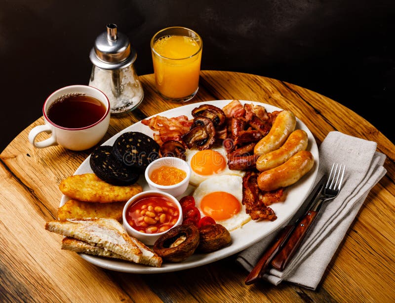 Full fry up English breakfast with fried eggs, sausages, bacon royalty free stock photo Full fry up English breakfast with fried eggs, sausages, bacon royalty free stock photo