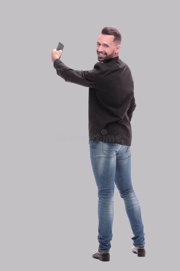 In full growth. young man dialing a number on his smartphone royalty free stock photo