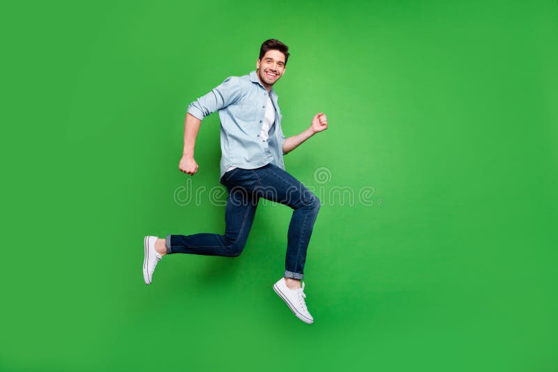 Full length body size photo side profile of running jumping ecstatic man wearing white sneakers smiling toothily urgent