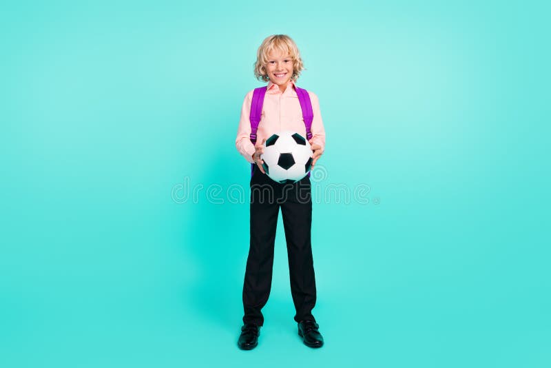 Full length body size view of attractive cheerful boy holding in hands ball isolated over bright teal turquoise color