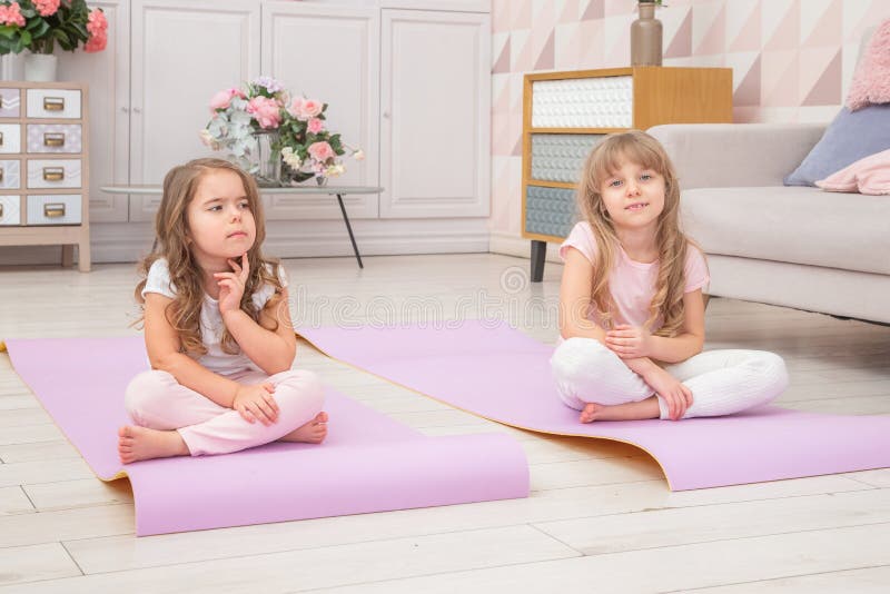 Full Length Front View Smiling Cute Girls Sitting on on Yoga Mat