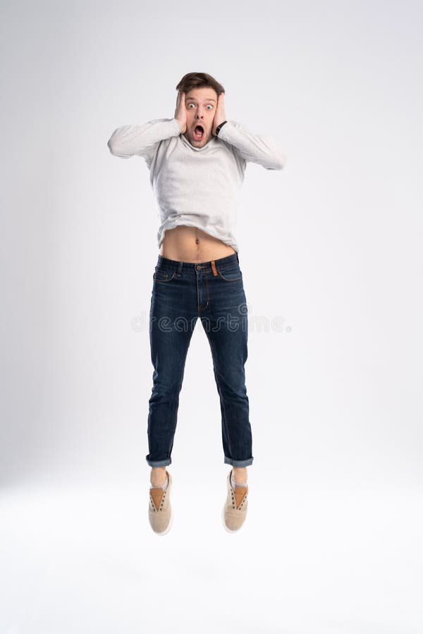 Full-length photo of funny man 30s in casual t-shirt and jeans jumping isolated over white background. stock images Full-length photo of funny man 30s in casual t-shirt and jeans jumping isolated over white background. stock images