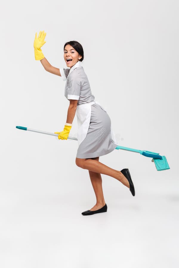 Full length photo of happy funny girl in uniform riding mop as a