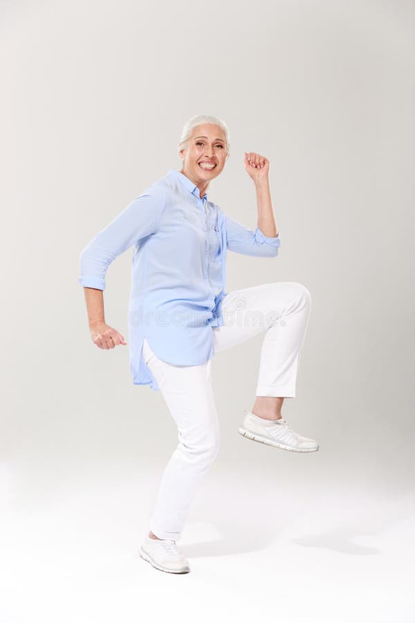 Full-length photo of playful old lady, having fun over white background royalty free stock photography Full-length photo of playful old lady, having fun over white background royalty free stock photography