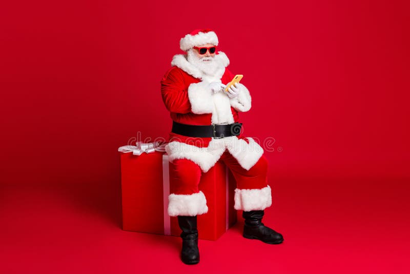 Full length photo of retired old man white beard hold telephone sit large box what chatting elf friend wear x-mas santa