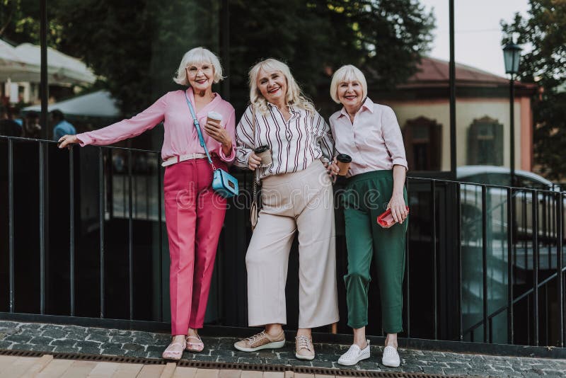 Beautiful ladies are standing near black fence stock photo Beautiful ladies are standing near black fence stock photo