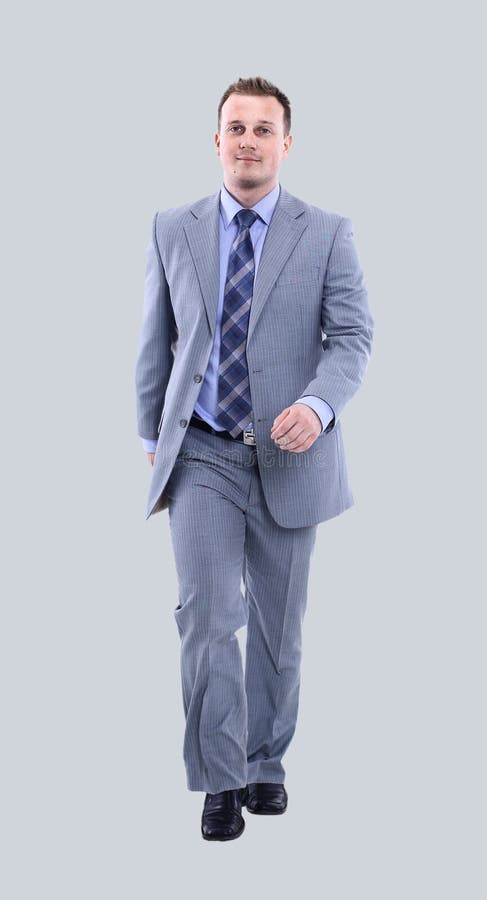 Full length picture of a business man walking on gray background