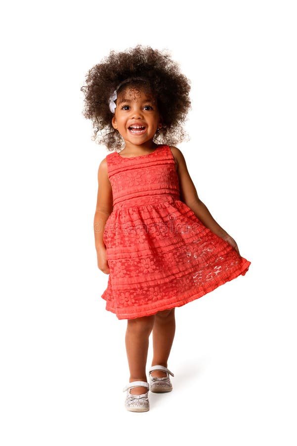 Full length portrait of cheerful african american little girl in dress of the color of the year 2019 coral, isolated over white background. Full length portrait of cheerful african american little girl in dress of the color of the year 2019 coral, isolated over white background