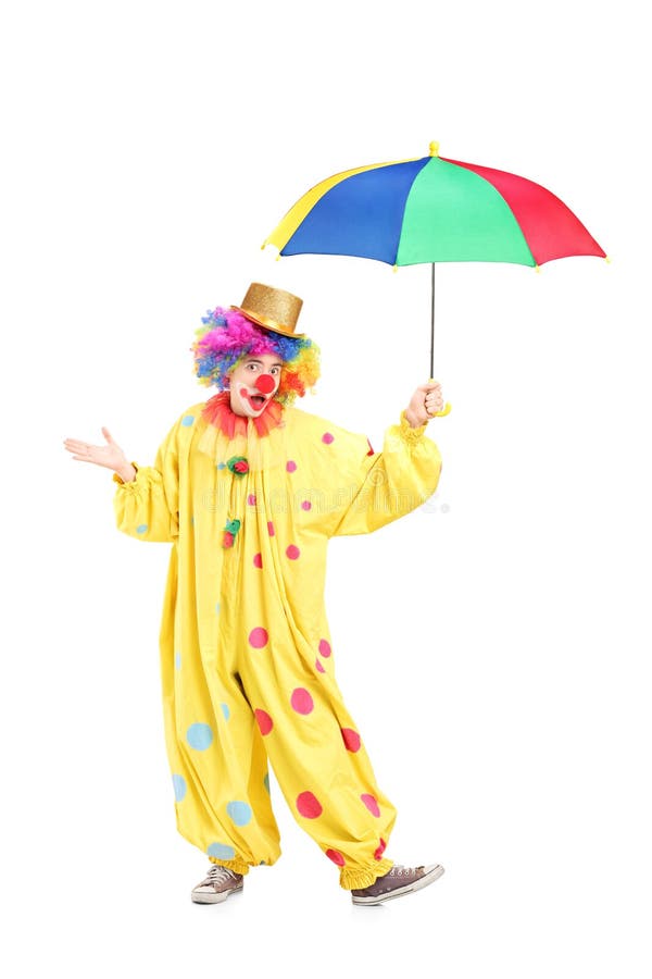Full length portrait of a cheerful clown holding an umbrella royalty free stock image
