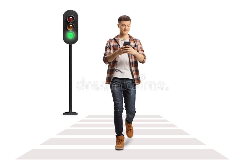 Man on mobile phone cross the road at a pedestrian crossing. Ho