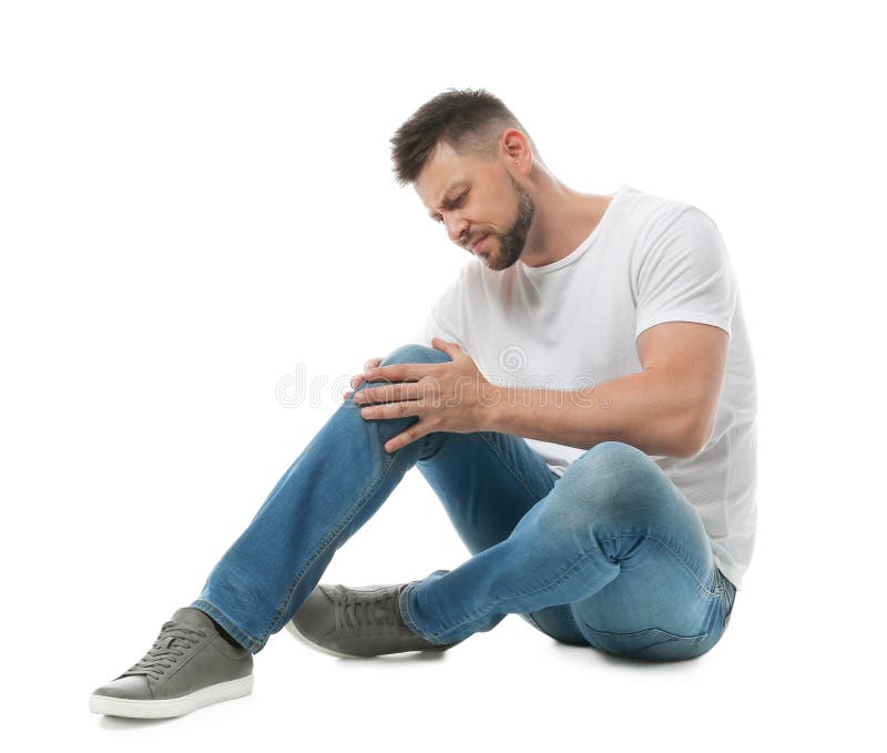 Full Length Portrait Of Man With Knee Problems Sitting Stock Photo