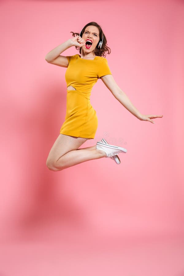 Full length portrait of pretty young woman in headphones having