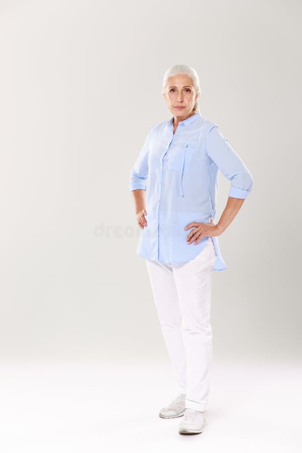 Full-length Portrait of Serious Old Lady in Blue Shirt and White Stock