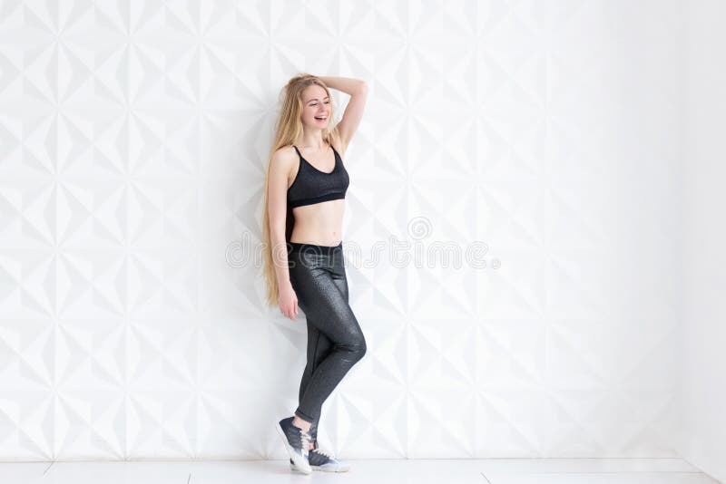 Full length portrait of young fit woman doing a yoga pose standing