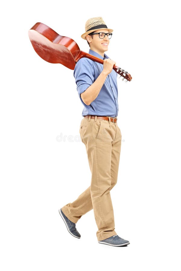 Full length portrait of young man holding an acoustic guitar over his shoulder