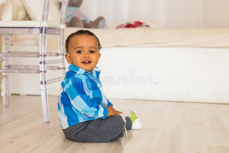 Full length portrait of a young mixed race boy sitting on the floor. royalty free stock photos Full length portrait of a young mixed race boy sitting on the floor. royalty free stock photos