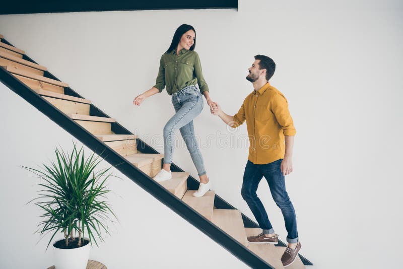 Full length profile photo of handsome guy and his pretty lady walking to bedroom going up stairs in just bought modern