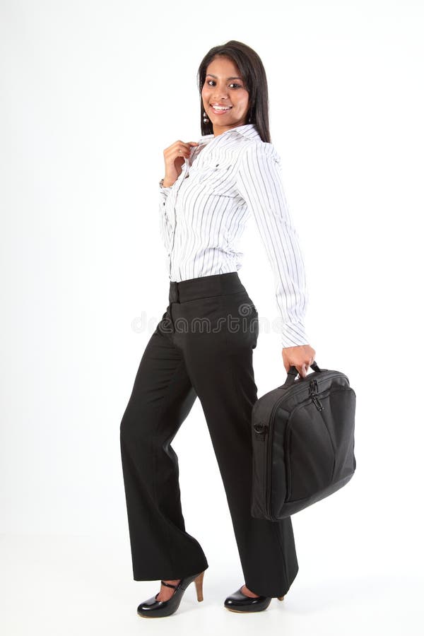 Beautiful young business woman with big happy smile standing in a relaxed pose wearing heels holding laptop bag in one hand. Beautiful young business woman with big happy smile standing in a relaxed pose wearing heels holding laptop bag in one hand