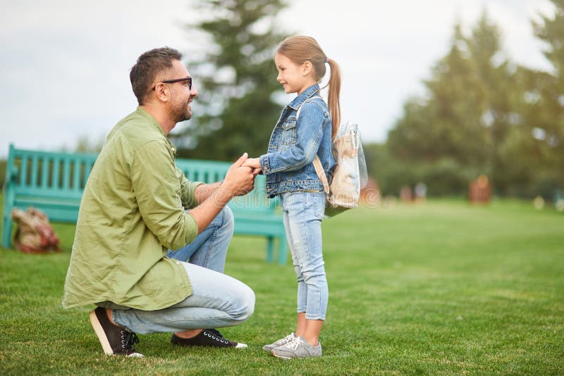 Full length shot of happy young father holding daughter`s hands, daddy spending time with his cute little girl in the