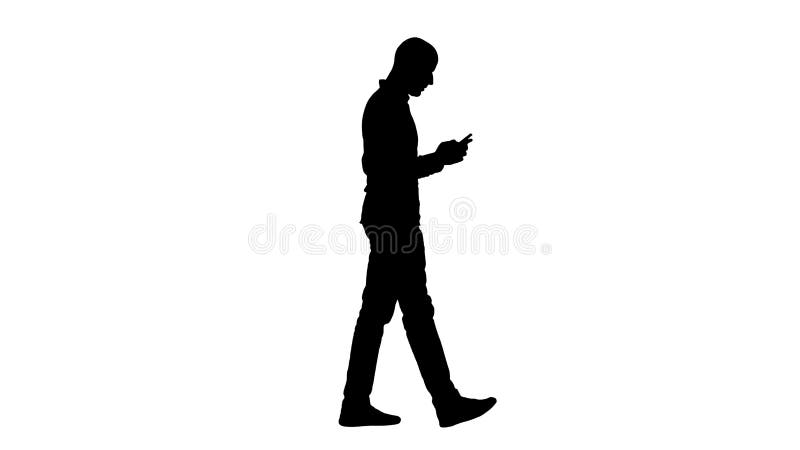 Full length shot. Side view. Silhouette Young man walking and using a phone. Professional shot in 4K resolution. 011. You can use it e.g. in your commercial video, business, presentation, broadcast