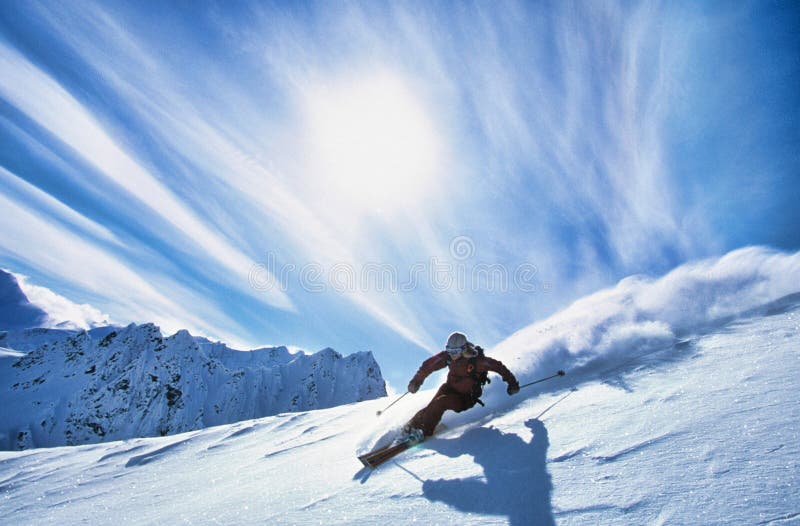 Full length of skier skiing on fresh powder snow. Full length photo of skier skiing on fresh powder snow