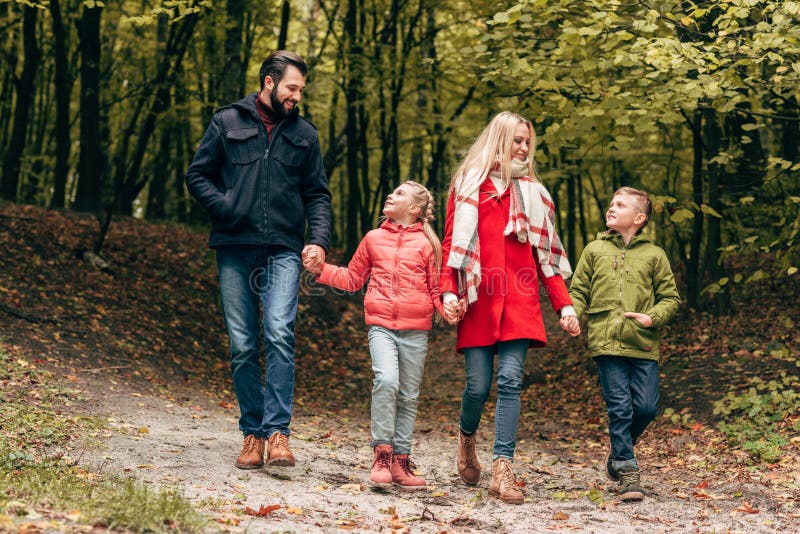 full length view of happy family holding hands and walking royalty free stock photos full length view of happy family holding hands and walking royalty free stock photos